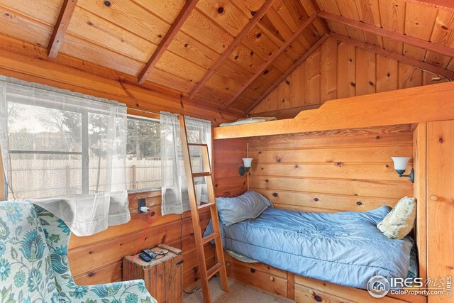 living area with carpet floors, wood ceiling, vaulted ceiling, wood walls, and a fireplace