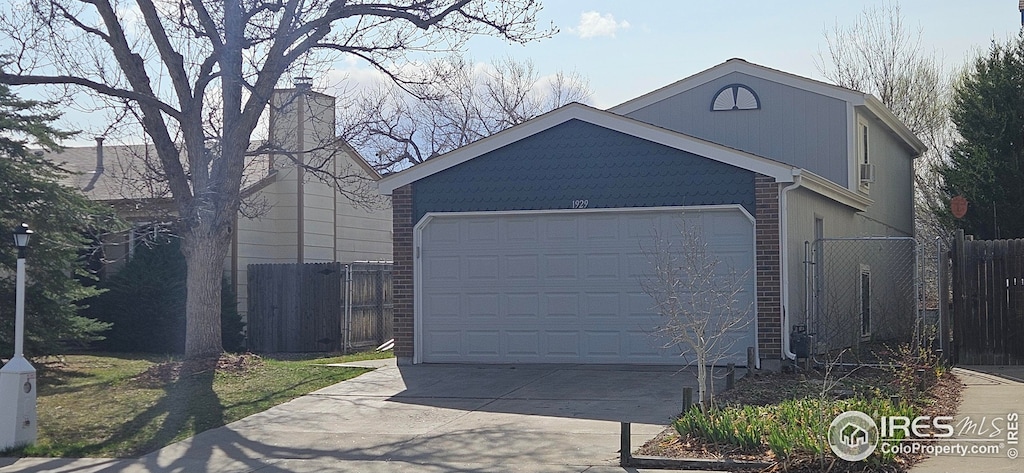 garage with fence and driveway