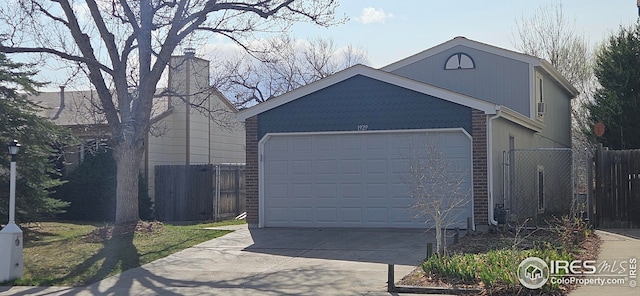 garage with fence and driveway