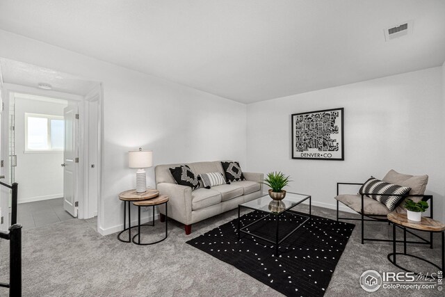 living room with visible vents, baseboards, and carpet