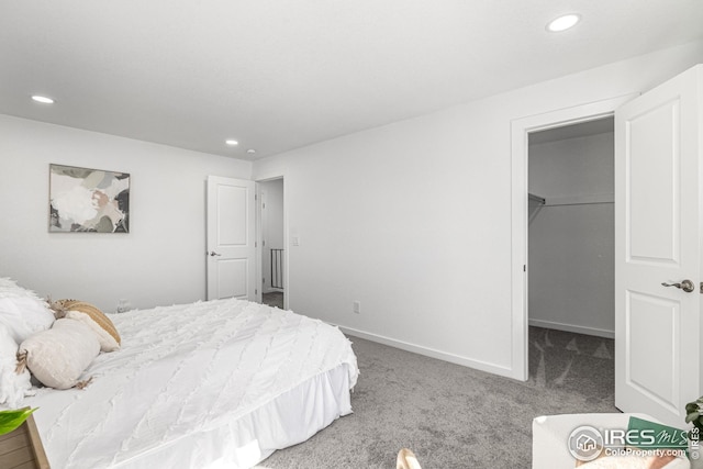 bedroom featuring recessed lighting, a spacious closet, and carpet flooring