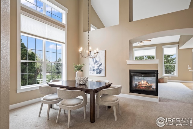 3122 Notabon Ct, Lafayette, CO 80026 - carpeted dining room featuring plenty of natural light, a towering ceiling, a multi sided fireplace, and a chandelier