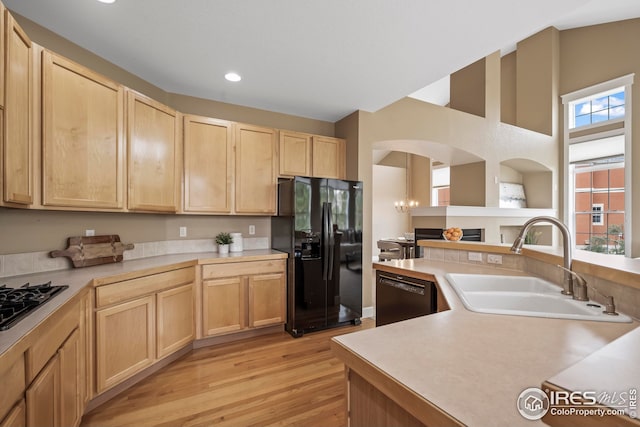3122 Notabon Ct, Lafayette, CO 80026 - kitchen featuring black fridge with ice dispenser, light brown cabinetry, dishwasher, light countertops, and light wood-style floors