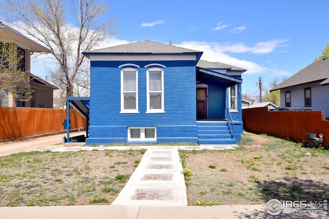 1021 5th St, Greeley, CO 80631 - view of front of home featuring fence, roof with shingles, and covered porch