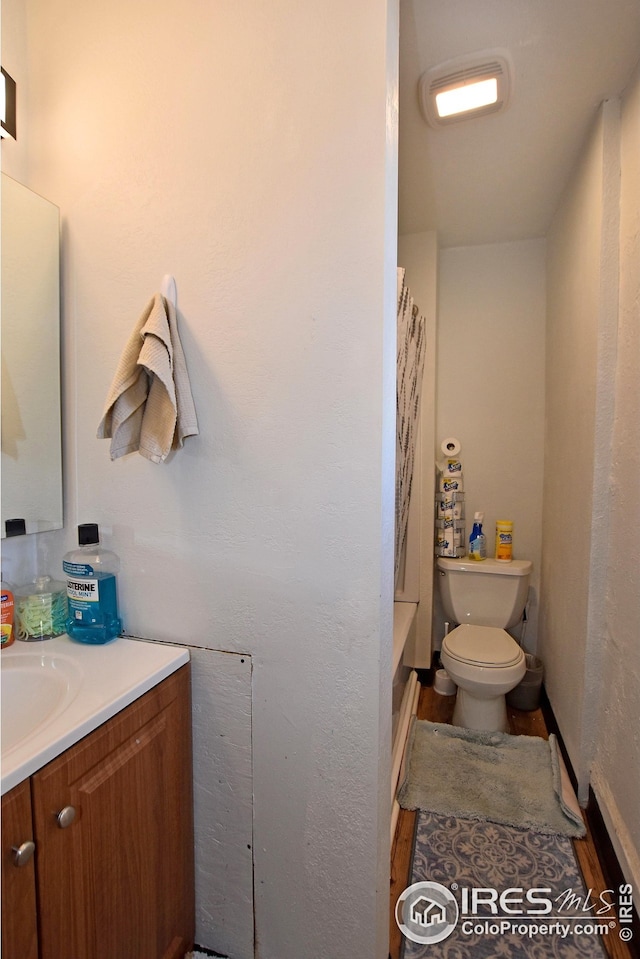 1021 5th St, Greeley, CO 80631 - full bath featuring wood finished floors, toilet, and vanity