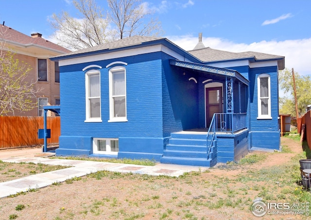 1021 5th St, Greeley, CO 80631 - view of front of home with brick siding, roof with shingles, and fence