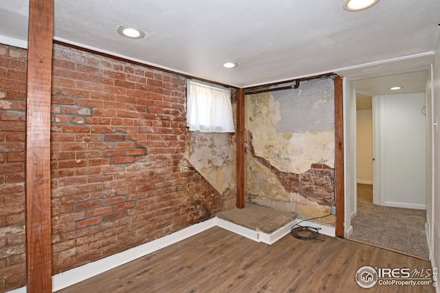 1021 5th St, Greeley, CO 80631 - below grade area with brick wall, baseboards, wood finished floors, and recessed lighting