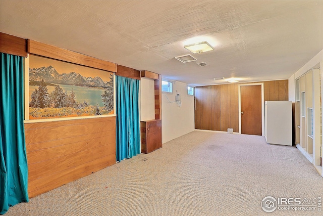 basement with wooden walls and carpet flooring