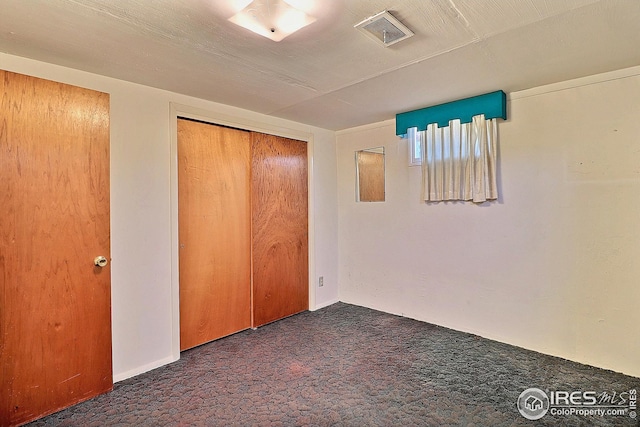 unfurnished bedroom featuring a closet, visible vents, carpet floors, and baseboards