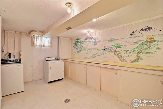 interior space featuring cream cabinetry, washer and dryer, light countertops, and concrete flooring