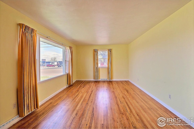 spare room with visible vents, light wood-style flooring, and baseboards