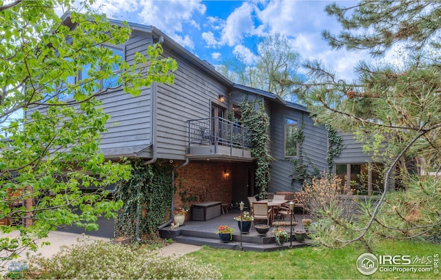 exterior space with a balcony and brick siding