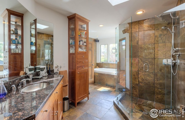 full bathroom with recessed lighting, vanity, a bath, a skylight, and a stall shower