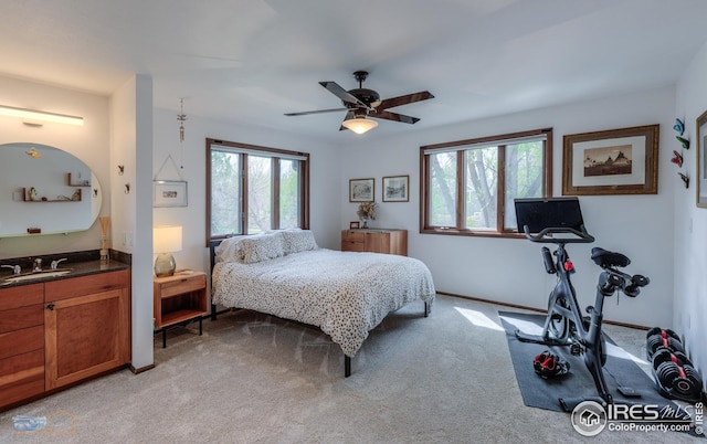bedroom with light colored carpet, ceiling fan, and a sink