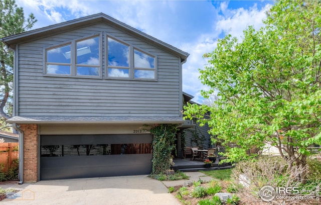 view of side of property featuring an attached garage, driveway, and brick siding