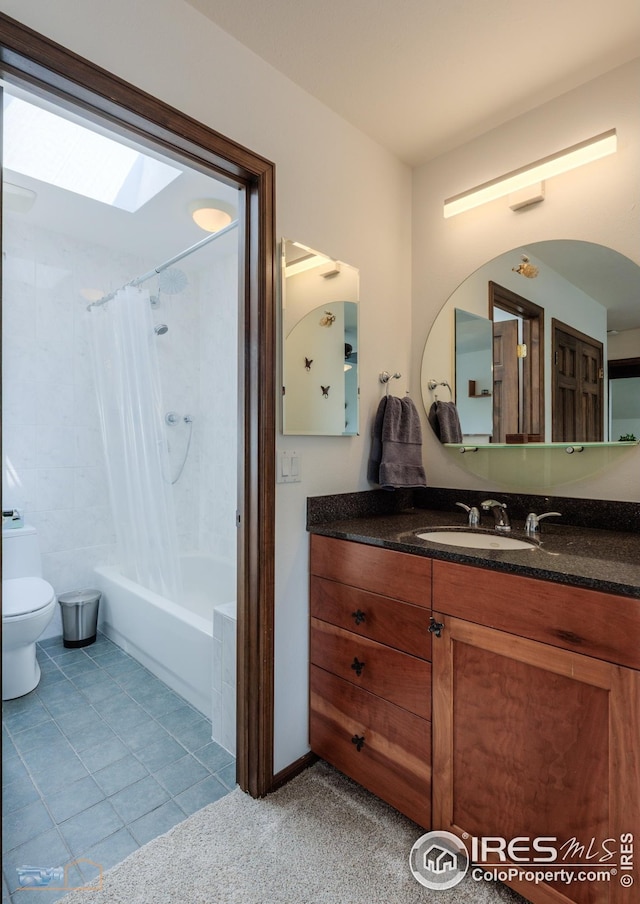 bathroom featuring tile patterned floors, shower / bath combination with curtain, toilet, vanity, and a skylight