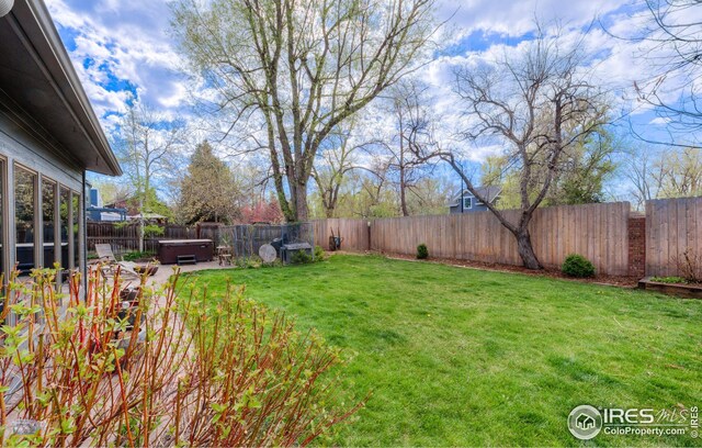 view of yard with a fenced backyard and a hot tub