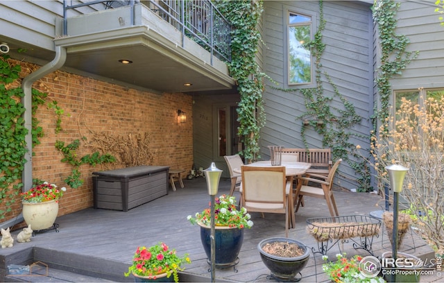 view of patio featuring outdoor dining area, a deck, and a balcony