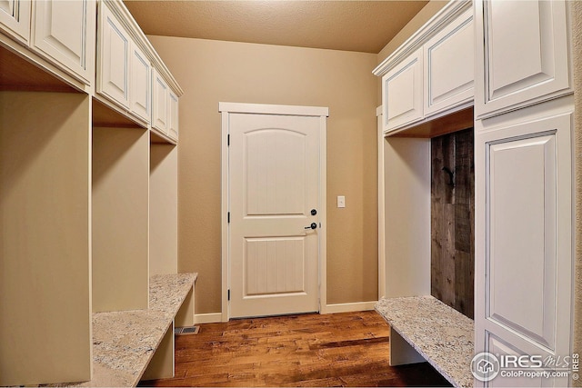 mudroom featuring dark wood finished floors and baseboards