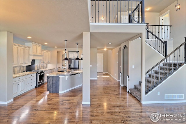 kitchen with a sink, baseboards, visible vents, stainless steel gas range, and dark wood-style floors