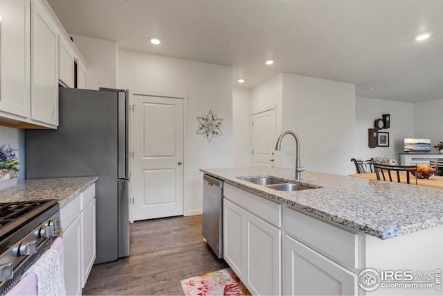 kitchen with white cabinetry, stainless steel appliances, dark wood finished floors, and a sink