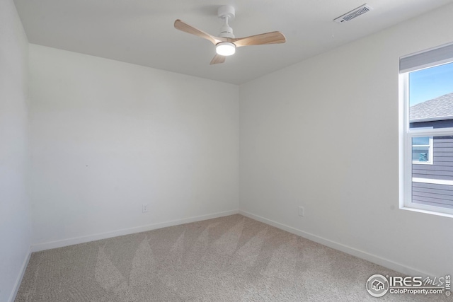 carpeted empty room with visible vents, ceiling fan, and baseboards