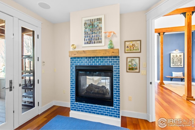1533 Old Tale Rd, Boulder, CO 80303 - living room featuring a tile fireplace, wood finished floors, and french doors