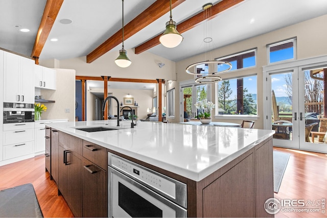 1533 Old Tale Rd, Boulder, CO 80303 - kitchen featuring french doors, light wood-type flooring, a spacious island, white cabinetry, and recessed lighting
