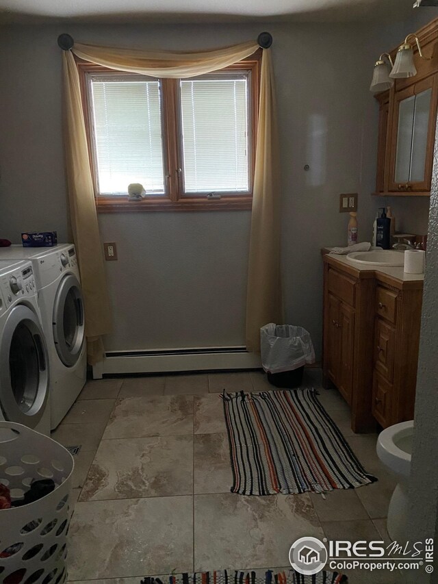 bathroom with a baseboard radiator, vanity, and washing machine and dryer