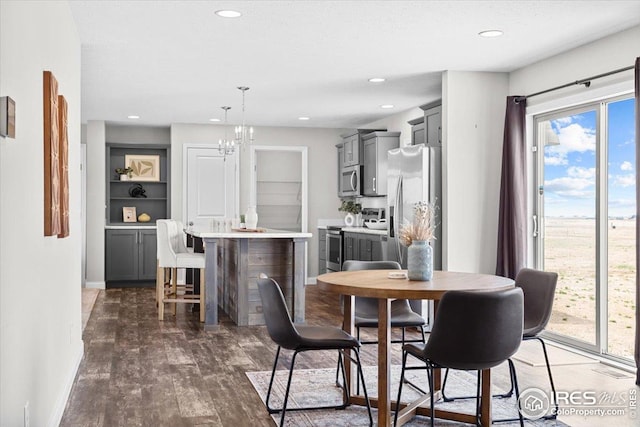 dining area featuring an inviting chandelier, dark wood-type flooring, recessed lighting, and baseboards