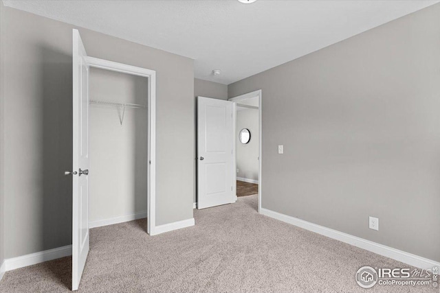 unfurnished bedroom featuring baseboards, a closet, and carpet