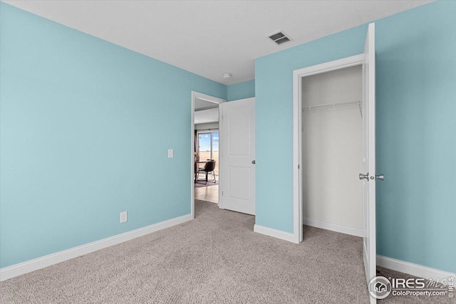 unfurnished bedroom with a closet, visible vents, carpet, and baseboards