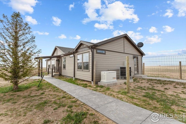 view of side of home featuring fence and central air condition unit