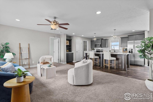 living area with recessed lighting, ceiling fan, and carpet floors