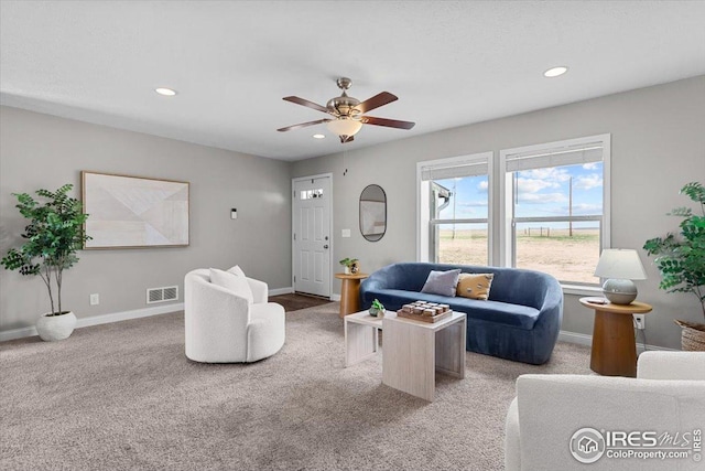 living area with baseboards, visible vents, light colored carpet, and recessed lighting