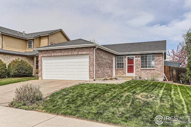 view of front of property featuring fence, a front lawn, concrete driveway, and brick siding