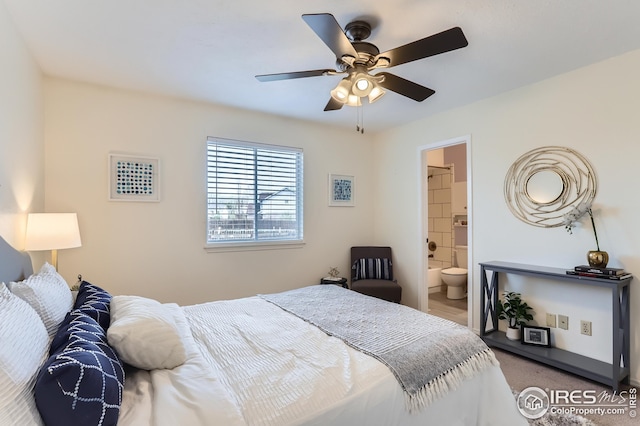 carpeted bedroom featuring a ceiling fan and ensuite bath