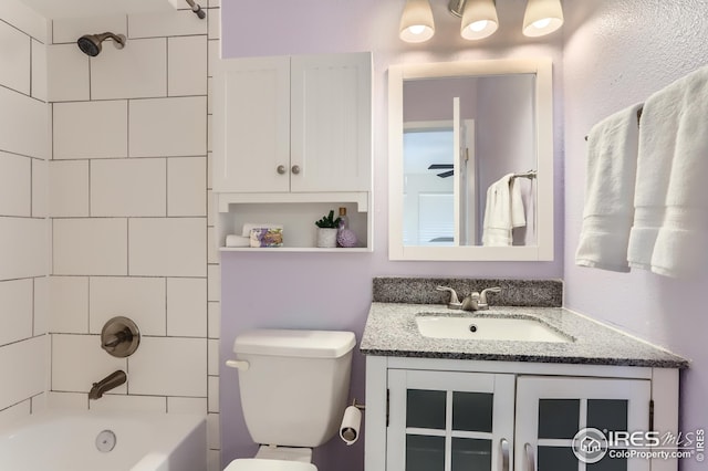 bathroom featuring vanity, toilet, and bathing tub / shower combination