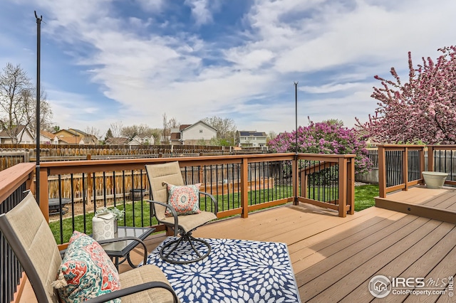 wooden deck with a fenced backyard and a residential view