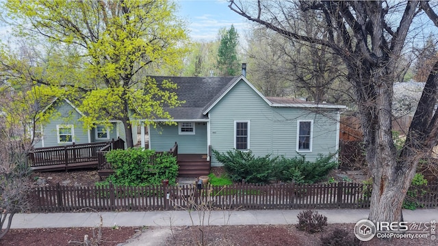 ranch-style house with a shingled roof and a fenced front yard