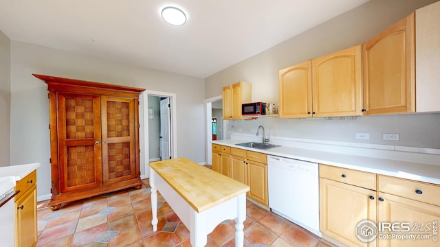 kitchen featuring a sink, light brown cabinetry, dishwasher, and black microwave