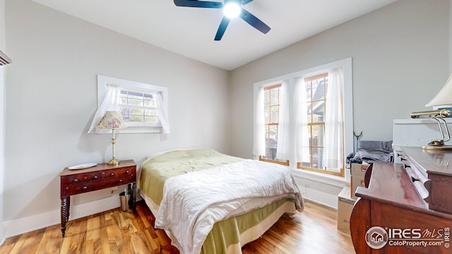 bedroom featuring light wood-type flooring, a ceiling fan, and baseboards