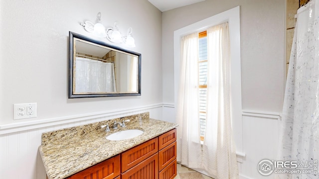 full bathroom with vanity and wainscoting