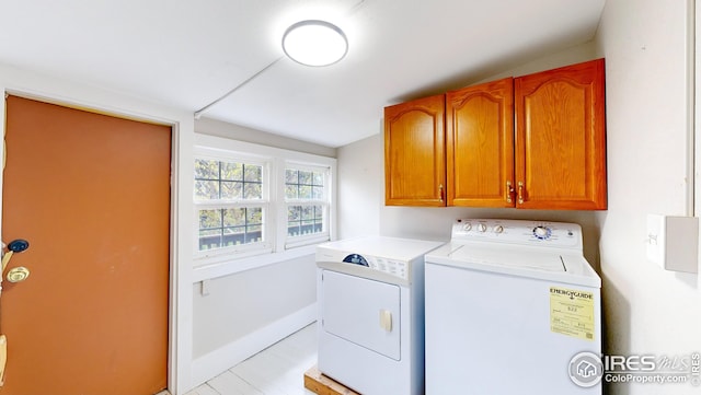 laundry area featuring washer and dryer, cabinet space, and baseboards