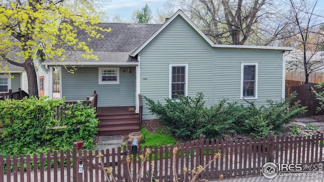 bungalow featuring a shingled roof and a fenced front yard