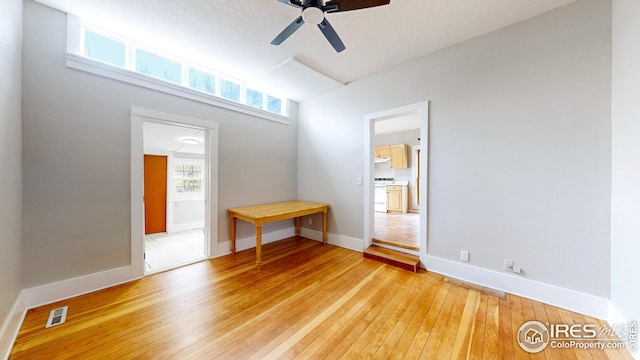 spare room with visible vents, a ceiling fan, light wood-style flooring, and baseboards