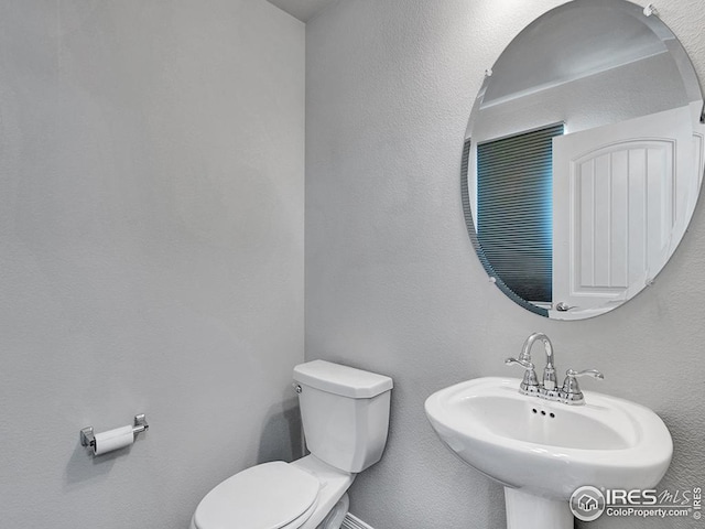 bathroom with toilet and a sink