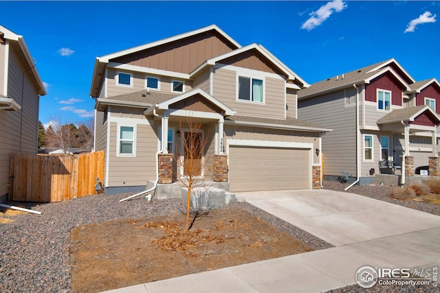 craftsman-style home with board and batten siding, fence, a garage, stone siding, and concrete driveway