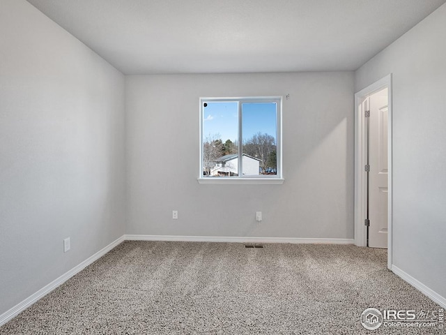 empty room with visible vents, carpet floors, and baseboards