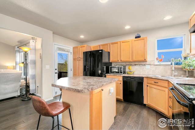 kitchen featuring black appliances, dark wood-type flooring, light brown cabinetry, and a sink